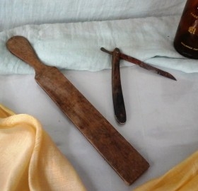Antiguo asentador manual de cuchillas de afeitar + vieja navaja. Alquiler props de barbería online.