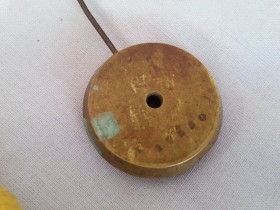 Péndulo viejo de reloj de pared. En bronce. Pesado. Para reutilizar. Old clock pendulum