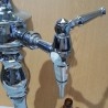 Columna cervecera en bronce blanco. Con su pingüino como tapa superior. Cervecerías La Cruz Blanca.