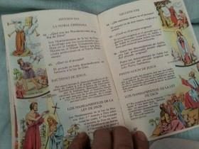 Medalla de La Virgen antigua. Año 1912 junto a libro de oraciones del año 1953