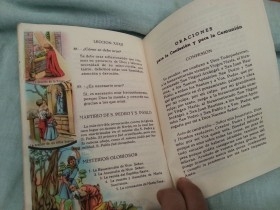 Medalla de La Virgen antigua. Año 1912 junto a libro de oraciones del año 1953