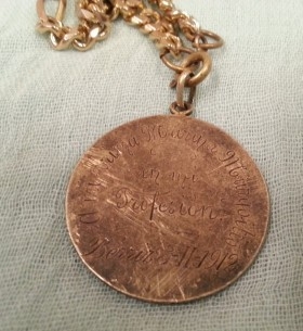 Medalla de La Virgen antigua. Año 1912 junto a libro de oraciones del año 1953