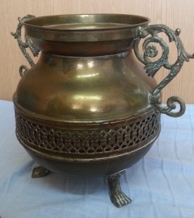 Jarrón vintage en metal dorado con patas en forma de garra de león.