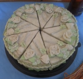 Tarta de cartón en bandeja con cajitas de regalo.