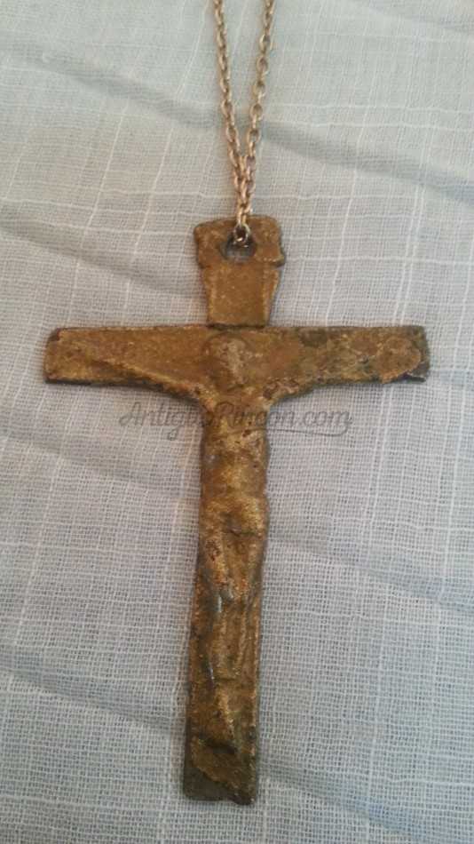 Crucifijo colgante en metal.