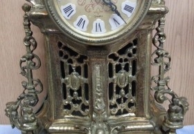 Reloj de mesa y dos candelabros en bronce.