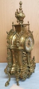 Reloj de mesa y dos candelabros en bronce.
