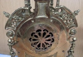 Reloj de mesa y dos candelabros en bronce.