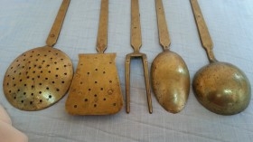 Utensilios de cocina en bronce. Conjunto de accesorios fuertes y pesados.